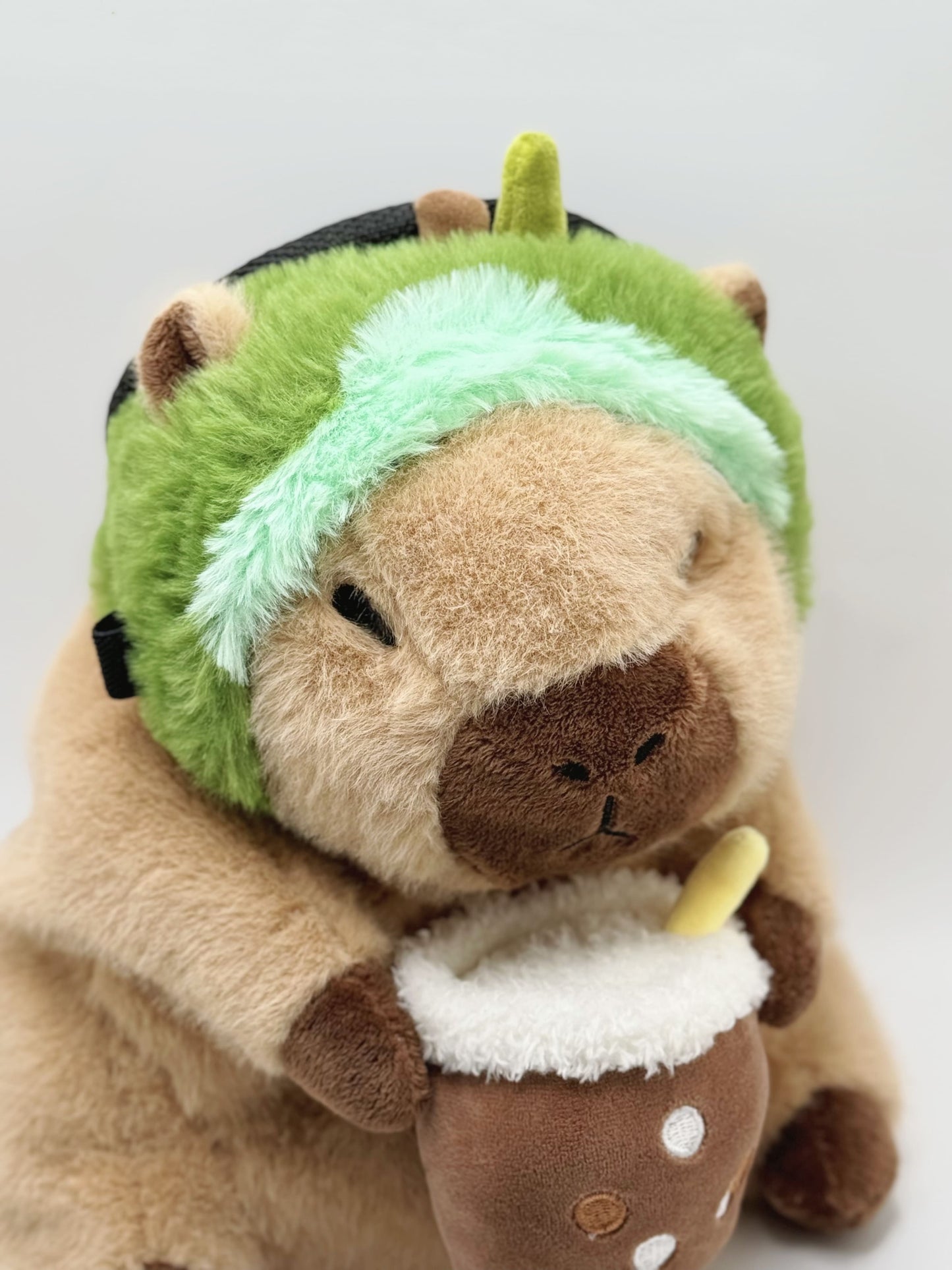 Handmade capybara-shaped climbing chalk bag dressed as avocado clutching a bubble tea cup