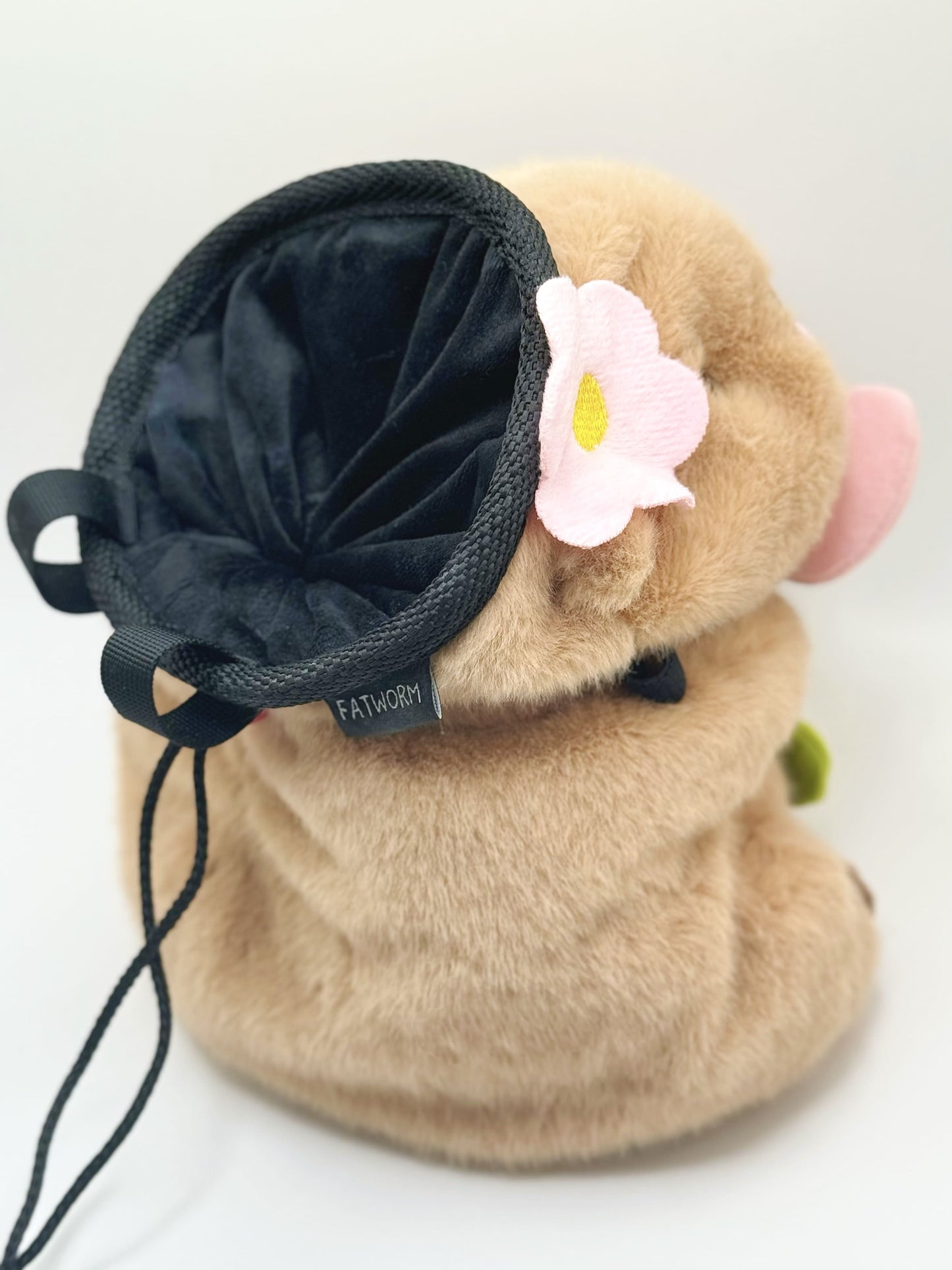 Handmade chalk bag featuring an adorable baby capybara holding a pink flower and wearing a cute dress-up outfit. Soft plush design, perfect for climbing and bouldering. Made by Fatworm