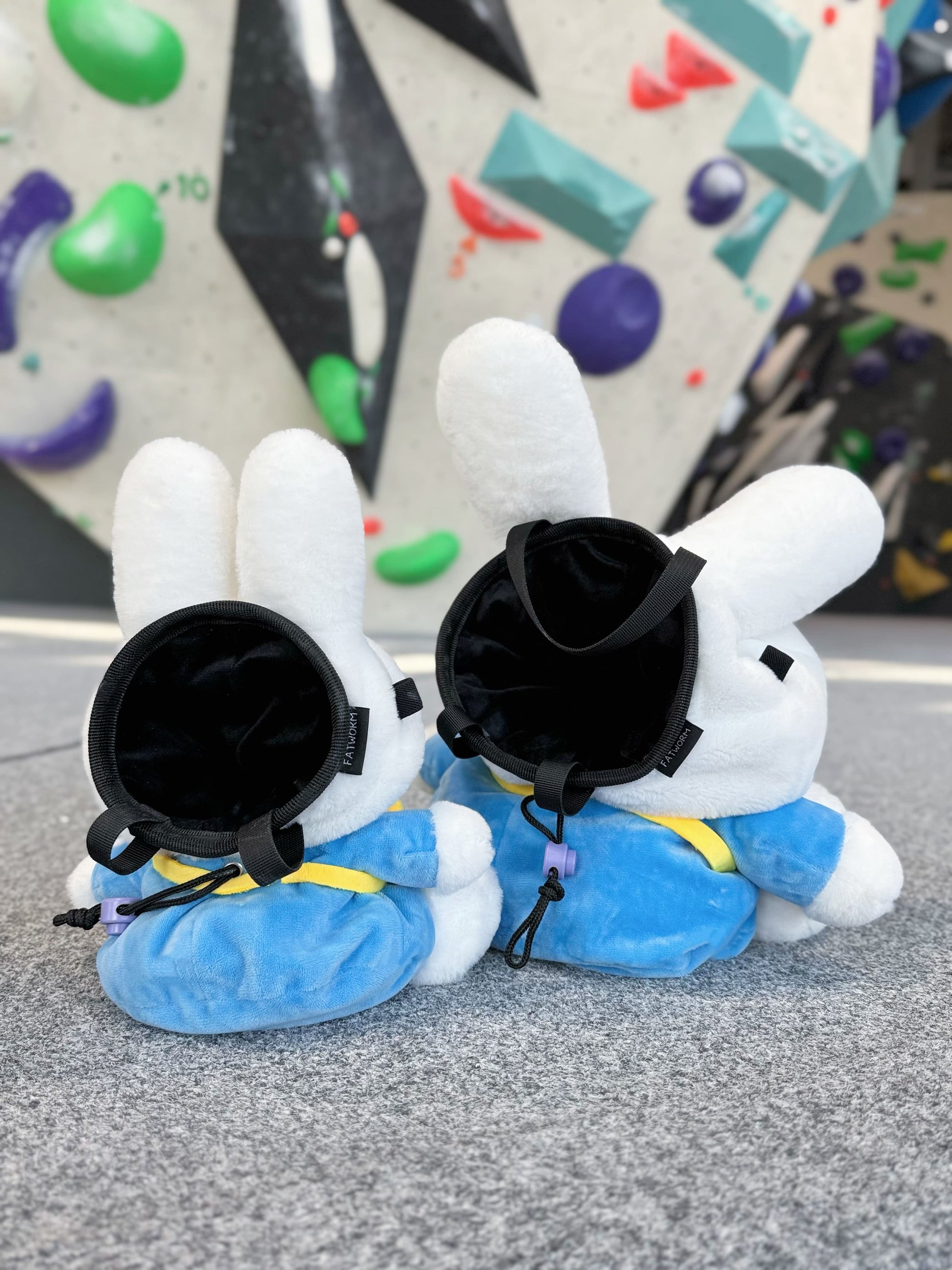 A cute anime plush miffy chalk bag by FATWORM featuring a white Vanilla Bunny wearing a blue dress and a yellow star backpack. This functional and fluffy bouldering accessory is handmade for bouldering and climbing for rock climbing, offering a long-durable design that makes the perfect climbing gift for a climber.