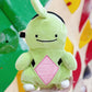 Handmade green and red plush Larvitar rock eater climbing chalk bag with a minimalist mimic face. Cute and unique climbing gift by Fatworm.