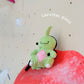 Handmade green and red plush Larvitar rock eater climbing chalk bag with a minimalist mimic face. Cute and unique climbing gift by Fatworm.