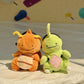 Handmade green and red plush Larvitar rock eater climbing chalk bag with a minimalist mimic face. Cute and unique climbing gift by Fatworm.