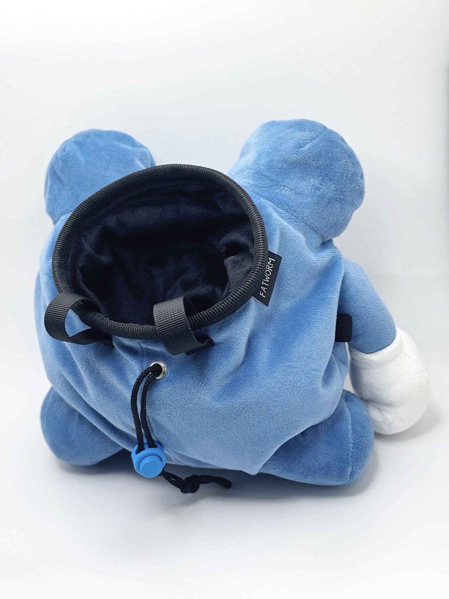 A cute anime plush chalk bag by FATWORM featuring a blue tadpole with a black and white swirl on its belly and white gloves. This functional and fluffy bouldering accessory is handmade for bouldering and climbing for rock climbing, offering a long-durable design that makes the perfect climbing gift for a climber.