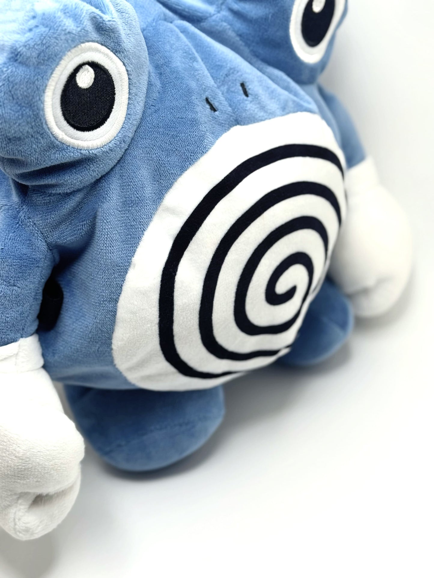 A cute anime plush chalk bag by FATWORM featuring a blue tadpole with a black and white swirl on its belly and white gloves. This functional and fluffy bouldering accessory is handmade for bouldering and climbing for rock climbing, offering a long-durable design that makes the perfect climbing gift for a climber.