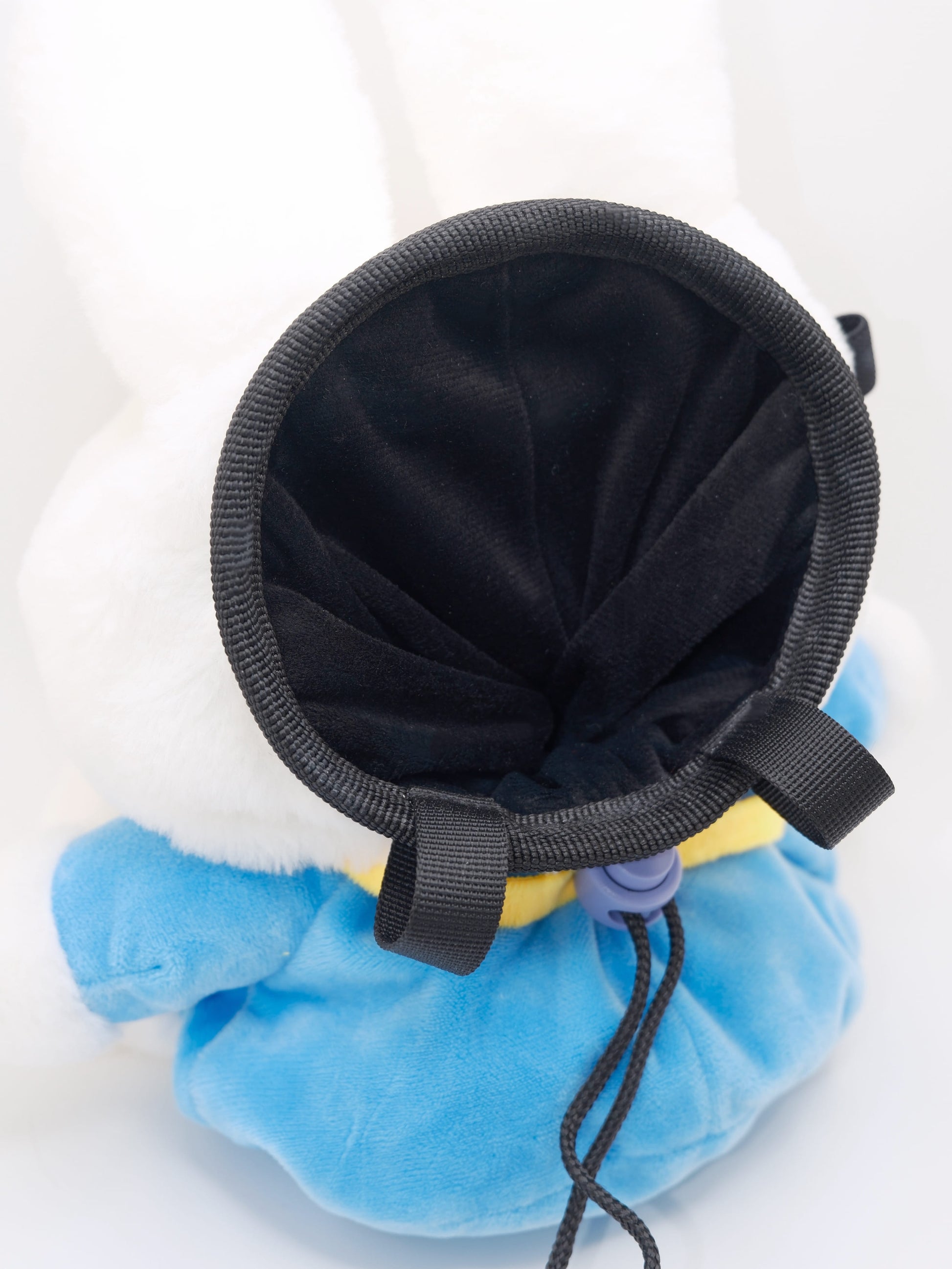 A cute anime plush chalk bag by FATWORM featuring a white Vanilla Bunny wearing a blue dress and a yellow star backpack. This functional and fluffy bouldering accessory is handmade for bouldering and climbing for rock climbing, offering a long-durable design that makes the perfect climbing gift for a climber.