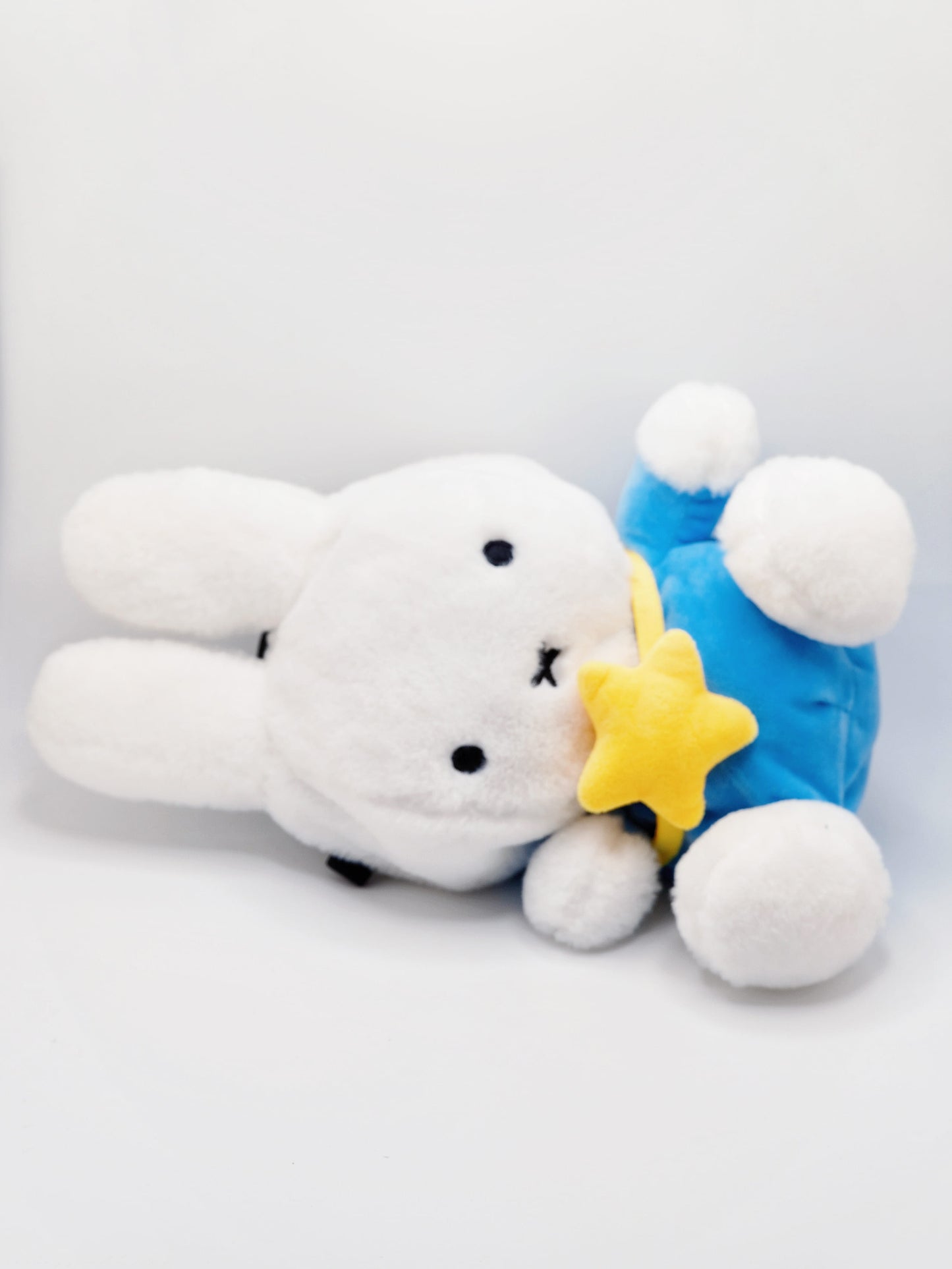 A cute anime plush chalk bag by FATWORM featuring a white Vanilla Bunny wearing a blue dress and a yellow star backpack. This functional and fluffy bouldering accessory is handmade for bouldering and climbing for rock climbing, offering a long-durable design that makes the perfect climbing gift for a climber.