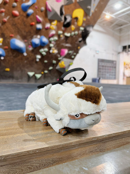 Handmade white and brown plush AP YIPYIP sky bison climbing chalk bag. Features six legs, arrow markings, and a cute animal silhouette. Professional bouldering gear with soft fleece lining. Perfect cute climbing gift by Fatworm.