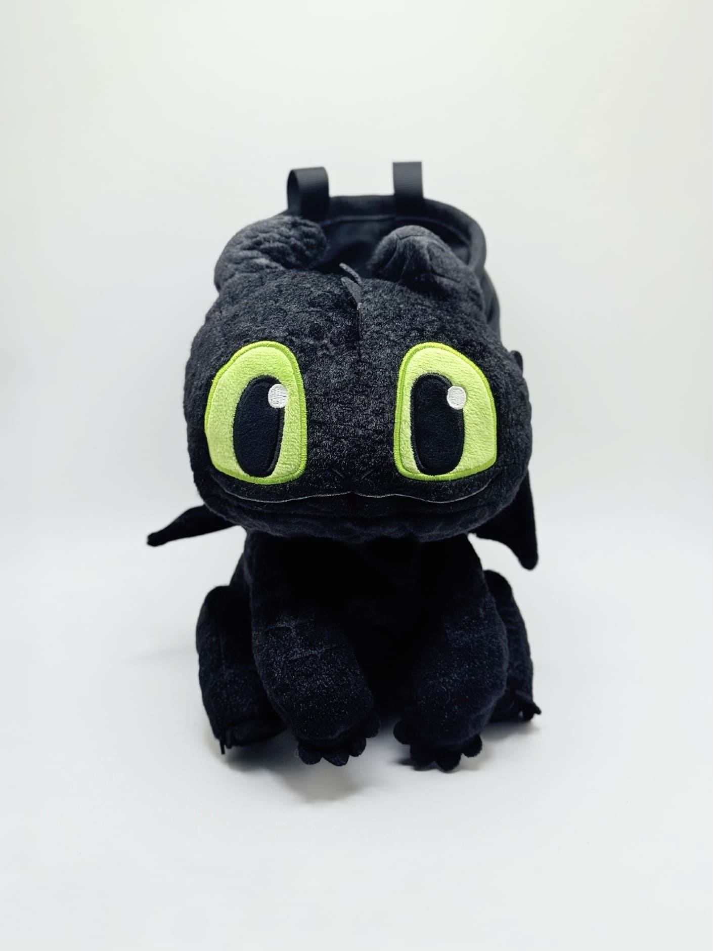 Baby Toothless dragon chalk bag for rock climbing and bouldering, featuring green eyes and Night Fury wings on black plush fabric.