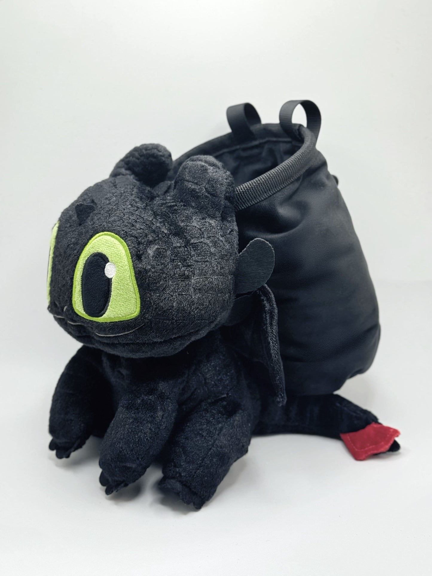 Baby Toothless dragon chalk bag for rock climbing and bouldering, featuring green eyes and Night Fury wings on black plush fabric.