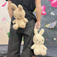 Handmade cream-colored Milk Tea Bunny plush climbing chalk bag with long floppy ears. Cute bouldering gift featuring a reinforced 12cm rim, secure drawstring, and deep black fleece lining. High-performance bouldering gear by Fatworm.