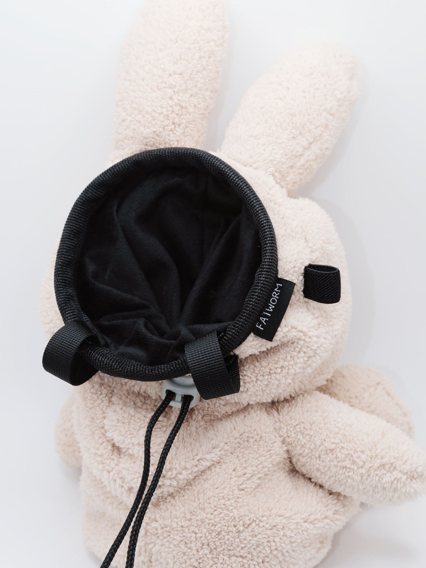 Handmade cream-colored Milk Tea Bunny plush climbing chalk bag with long floppy ears. Cute bouldering gift featuring a reinforced 12cm rim, secure drawstring, and deep black fleece lining. High-performance bouldering gear by Fatworm.