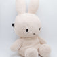 Handmade cream-colored Milk Tea Bunny plush climbing chalk bag with long floppy ears. Cute bouldering gift featuring a reinforced 12cm rim, secure drawstring, and deep black fleece lining. High-performance bouldering gear by Fatworm.