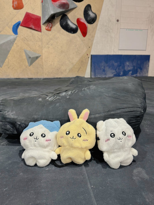 Three cute, fluffy handmade plush climbing chalk bags featuring Chiikawa, Usagi with a chaotic expression, and Hachiware. Designed with high functionality for climbers with wide top rim openings for easy chalk access and fleece-lined interiors. Perfect bouldering accessories and great climbing gifts.