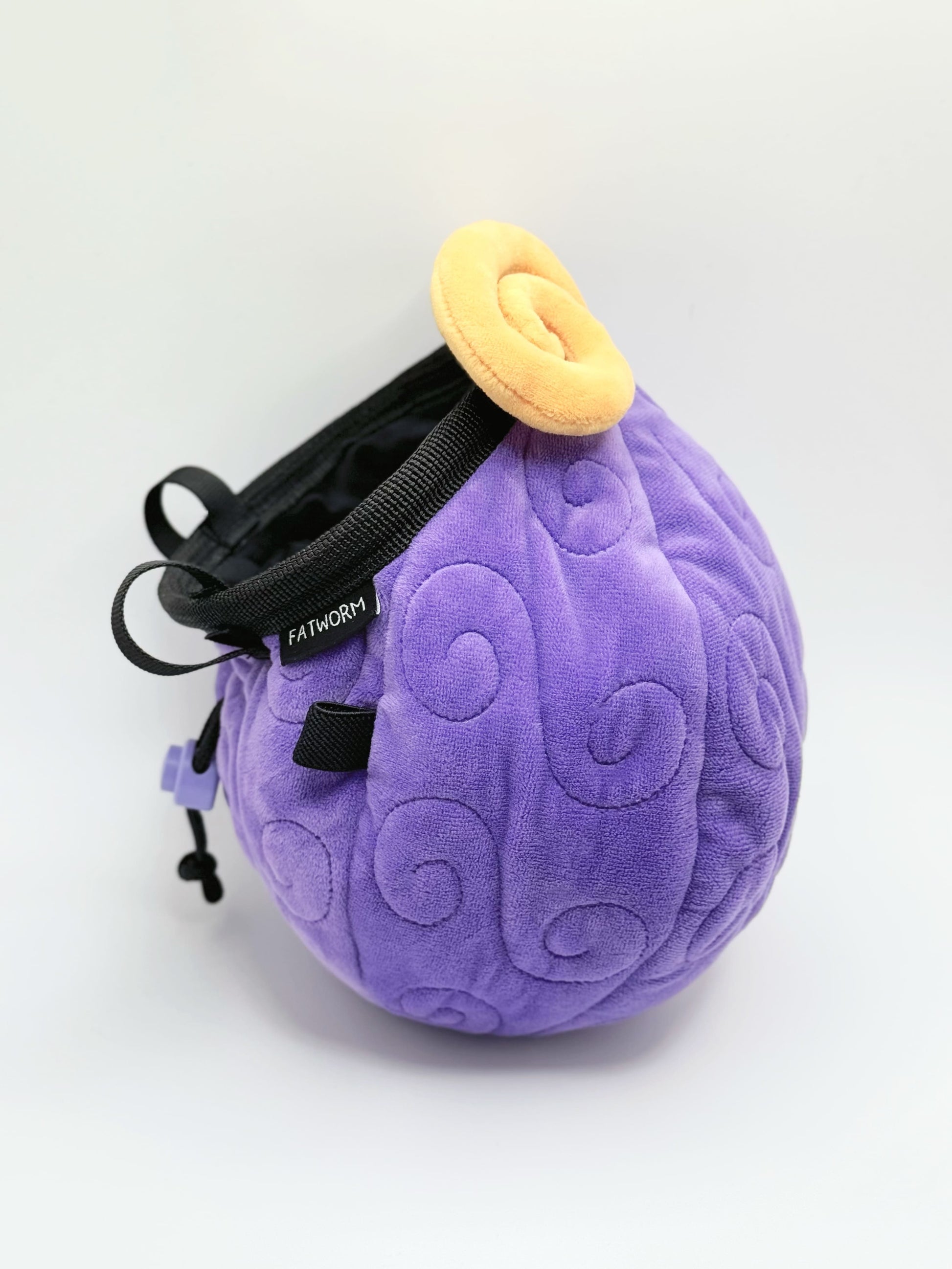 A soft and fluffy Gomu Gomu no Mi (Gum-Gum Fruit) plush chalk bag by Fatworm. This cute yet functional climbing gear features the iconic purple swirl pattern and a long-durable design. The perfect climbing gift for climbers who love unique, handmade gear.