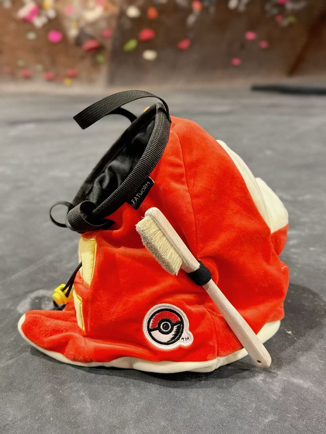 Pokémon Fuecoco climbing chalk bag/bucket featuring a soft plush exterior, spacious opening, and a stretchy brush holder, designed for rock climbers, handmade by Fatworm.