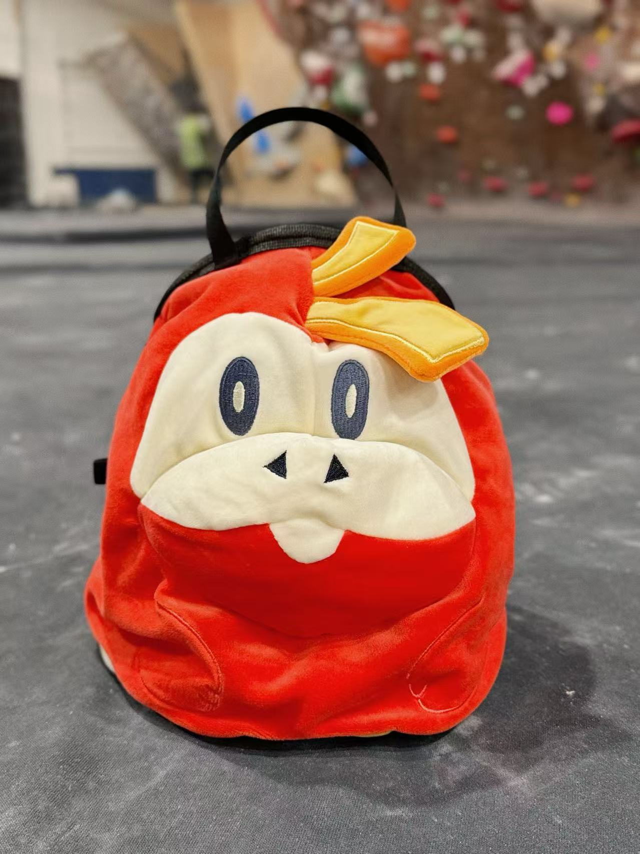 Pokémon Fuecoco climbing chalk bag/bucket featuring a soft plush exterior, spacious opening, and a stretchy brush holder, designed for rock climbers, handmade by Fatworm.