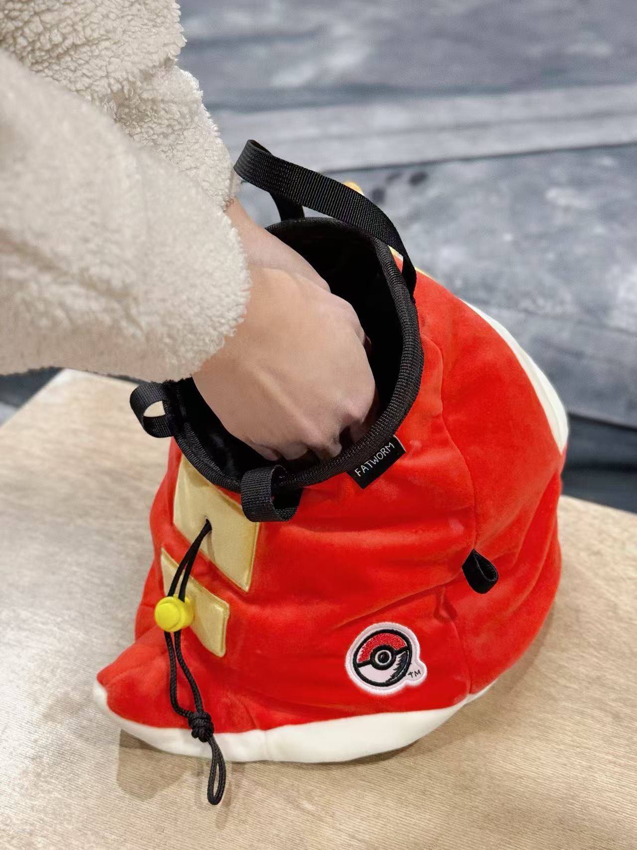 Pokémon Fuecoco climbing chalk bag/bucket featuring a soft plush exterior, spacious opening, and a stretchy brush holder, designed for rock climbers, handmade by Fatworm.