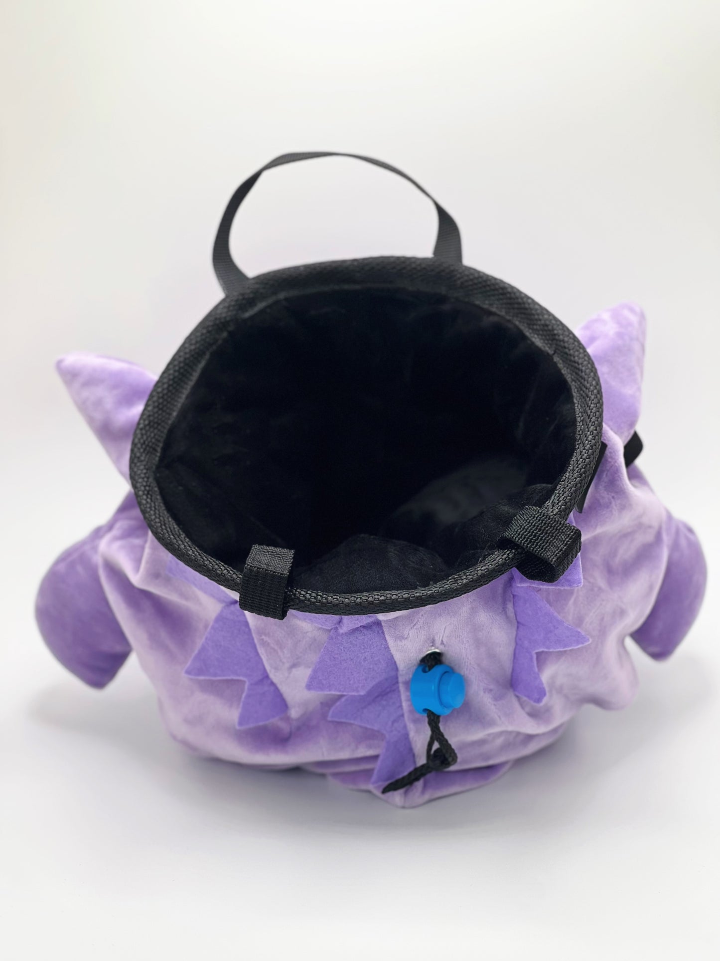 A cute, handmade plush climbing chalk bag featuring Ditto transformed into Gengar, with a purple ghost shape and Ditto’s iconic simple face. Designed with high functionality by a climber, it includes a wide top rim opening, polar fleece lining, a brush loop, and a spill-proof drawstring. A great bouldering gift for rock climbers.