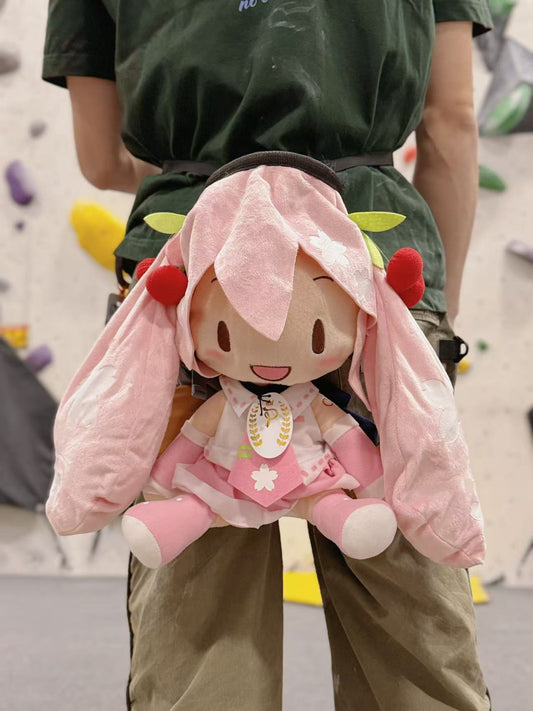A Limited Edition Sakura Miku plush chalk bag by Fatworm. This soft and fluffy bouldering accessory features a pastel pink cherry blossom theme and long-durable handmade construction. A cute and functional climbing gift for climbers who love unique gear.