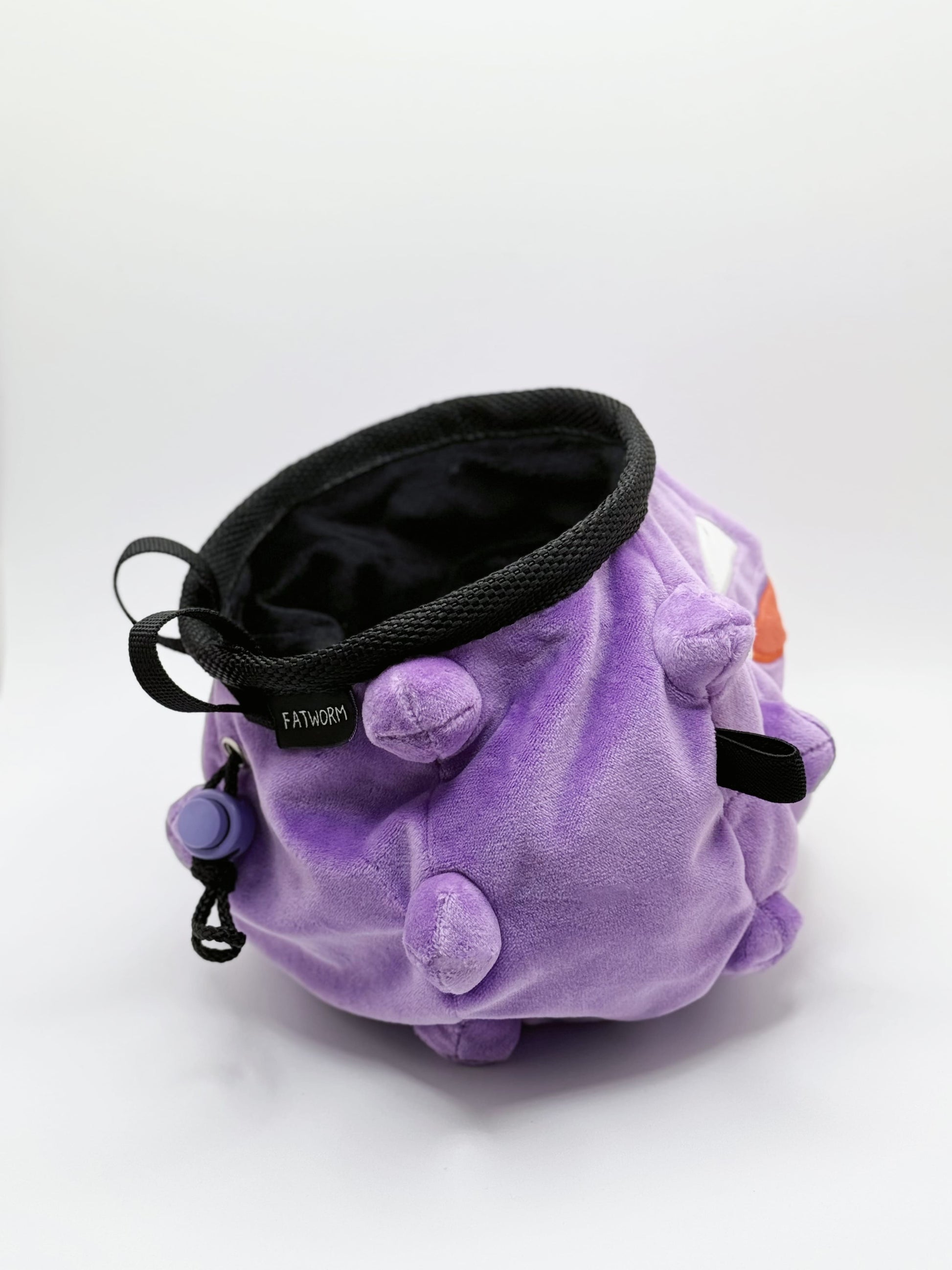A cute anime plush chalk bag designed like Koffing by Fatworm. This functional purple bouldering and climbing accessory is handmade with a soft exterior, secure drawstring, and brush loop, making it perfect for rock climbing and a great gear addition for any climber.