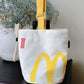 A cute anime plush chalk bag by Fatworm inspired by a famous fast food brand. This red functional bag features a vibrant yellow handle, a secure closure to prevent chalk spills, and a long-durable design, making it the perfect climbing gift for a climber into bouldering and climbing for rock climbing.