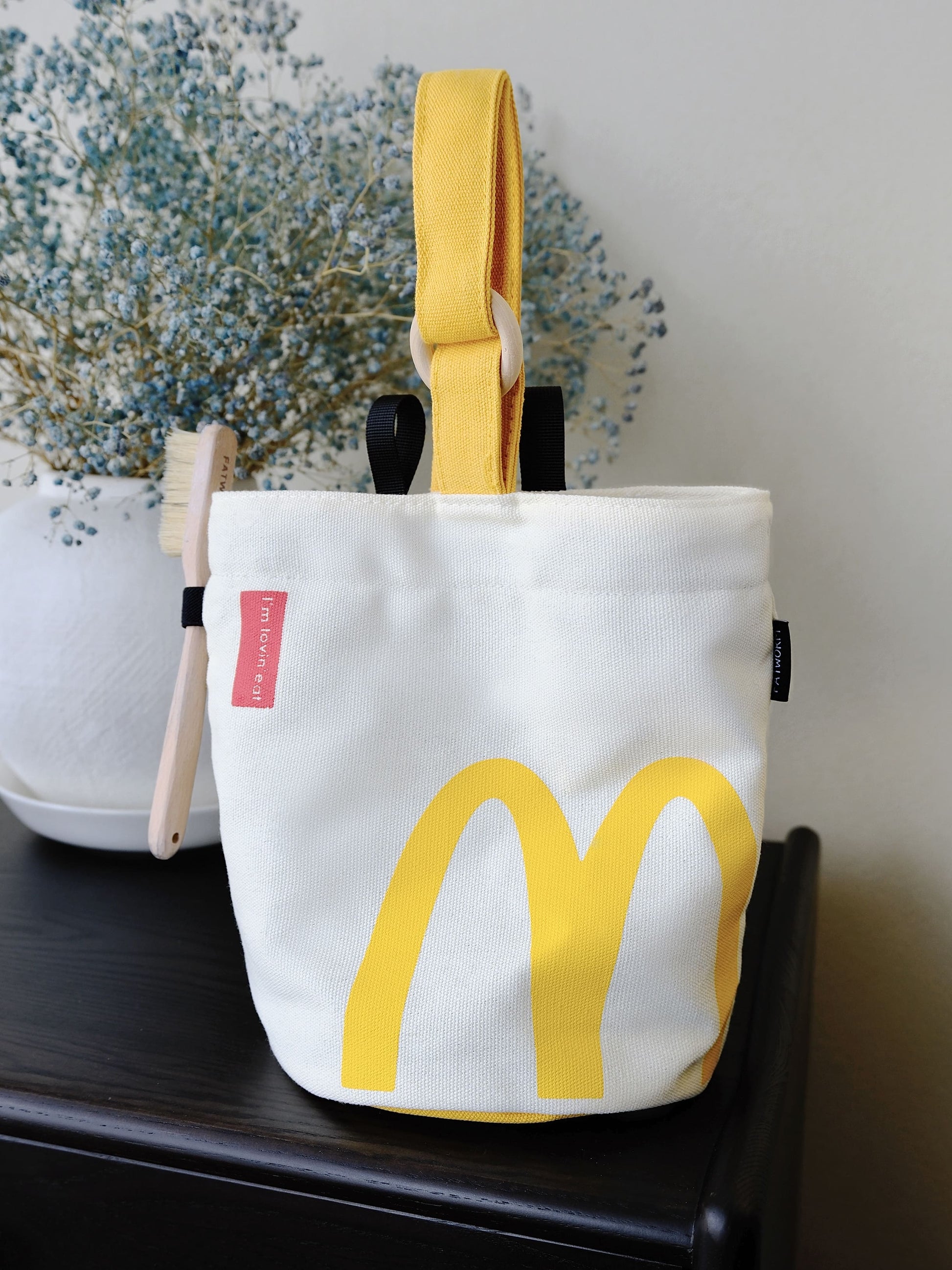 A cute anime plush chalk bag by Fatworm inspired by a famous fast food brand. This red functional bag features a vibrant yellow handle, a secure closure to prevent chalk spills, and a long-durable design, making it the perfect climbing gift for a climber into bouldering and climbing for rock climbing.