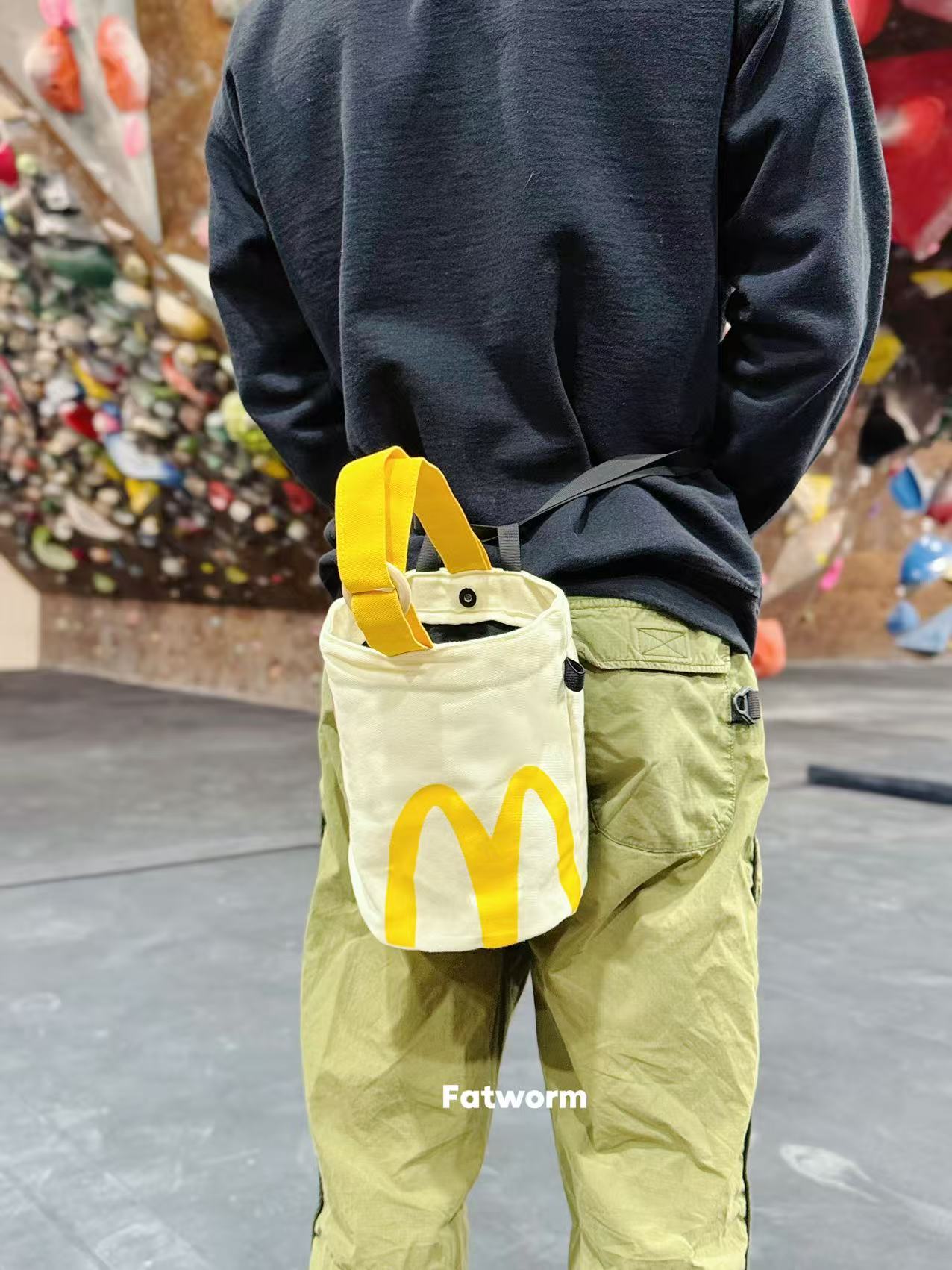 A cute anime plush chalk bag by Fatworm inspired by a famous fast food brand. This red functional bag features a vibrant yellow handle, a secure closure to prevent chalk spills, and a long-durable design, making it the perfect climbing gift for a climber into bouldering and climbing for rock climbing.