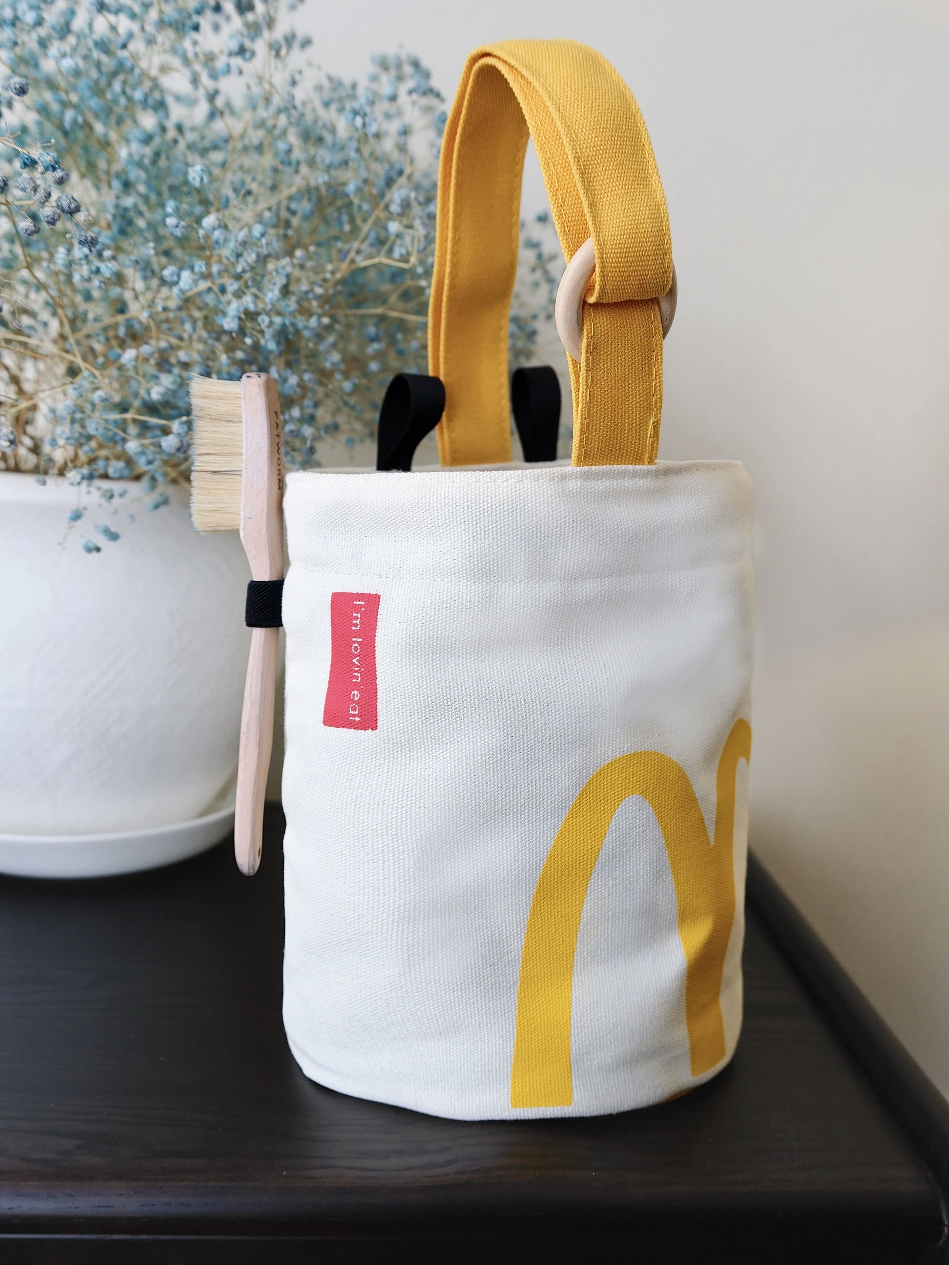 A cute anime plush chalk bag by Fatworm inspired by a famous fast food brand. This red functional bag features a vibrant yellow handle, a secure closure to prevent chalk spills, and a long-durable design, making it the perfect climbing gift for a climber into bouldering and climbing for rock climbing.