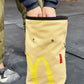 A cute plush bouldering chalk bucket by FATWORM featuring a classic red and yellow fast-food design. This functional and spacious ground-use accessory is handmade for bouldering and climbing for rock climbing, offering a long-durable design that makes the perfect climbing gift for a climber.