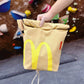 A cute plush bouldering chalk bucket by FATWORM featuring a classic red and yellow fast-food design. This functional and spacious ground-use accessory is handmade for bouldering and climbing for rock climbing, offering a long-durable design that makes the perfect climbing gift for a climber.