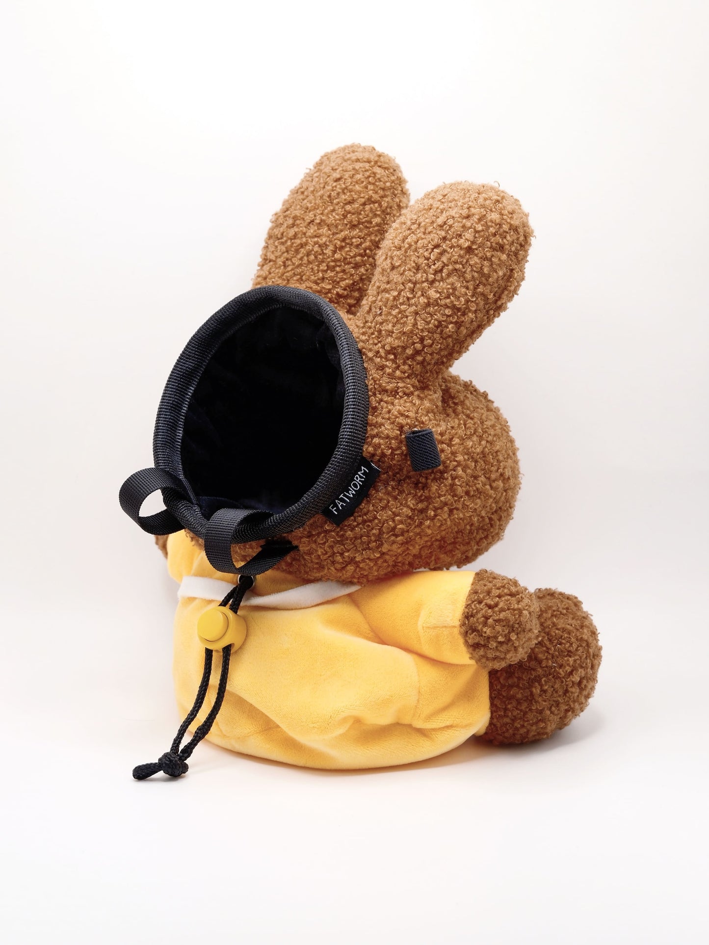 A cute anime plush chalk bag by FATWORM featuring a brown Mocha Bunny wearing a yellow dress. This functional and fluffy bouldering accessory is handmade for bouldering and climbing for rock climbing, offering a long-durable design that makes the perfect climbing gift for a climber.