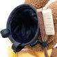 A cute anime plush chalk bag by FATWORM featuring a brown Mocha Bunny wearing a yellow dress. This functional and fluffy bouldering accessory is handmade for bouldering and climbing for rock climbing, offering a long-durable design that makes the perfect climbing gift for a climber.