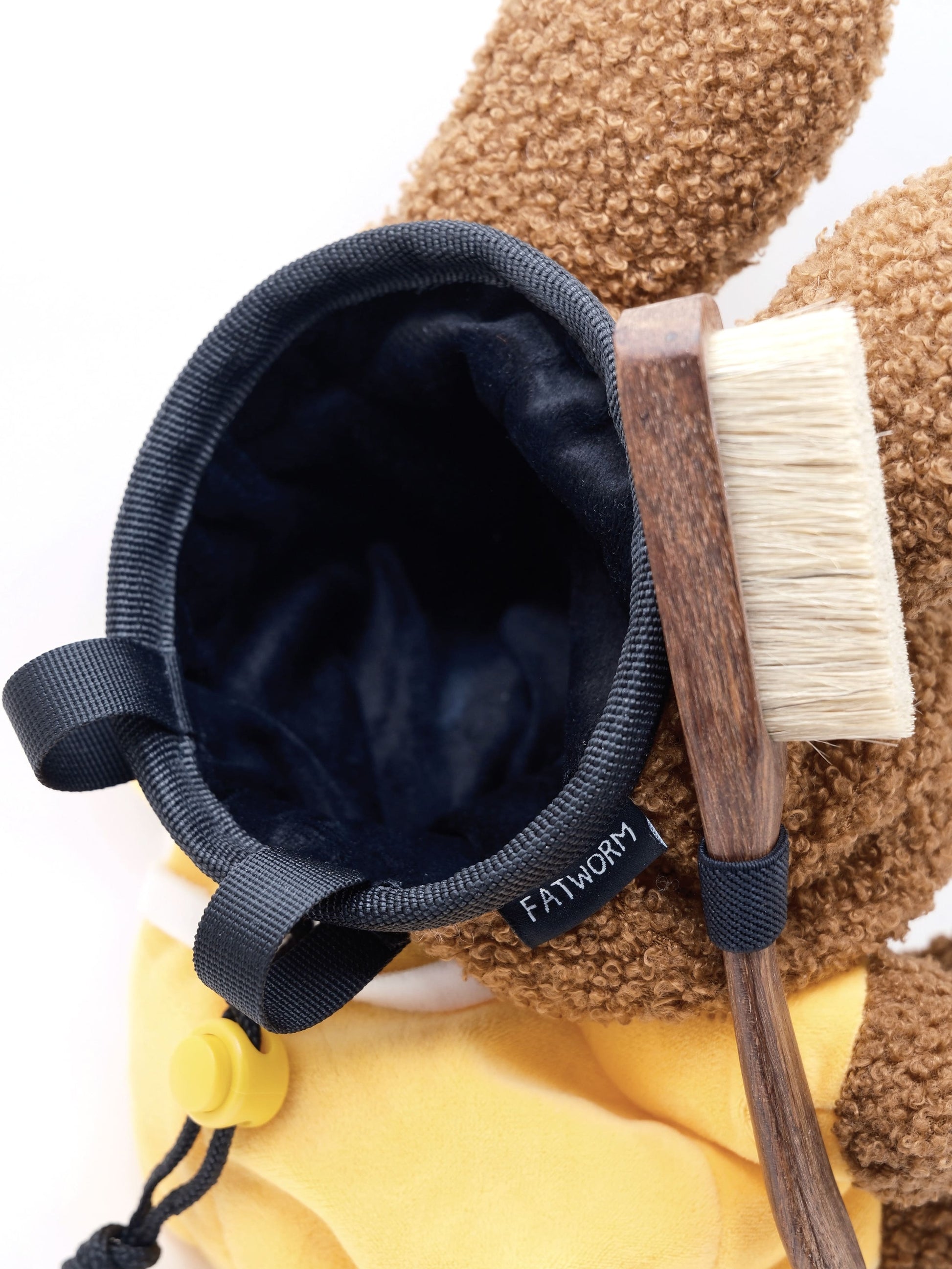 A cute anime plush chalk bag by FATWORM featuring a brown Mocha Bunny wearing a yellow dress. This functional and fluffy bouldering accessory is handmade for bouldering and climbing for rock climbing, offering a long-durable design that makes the perfect climbing gift for a climber.