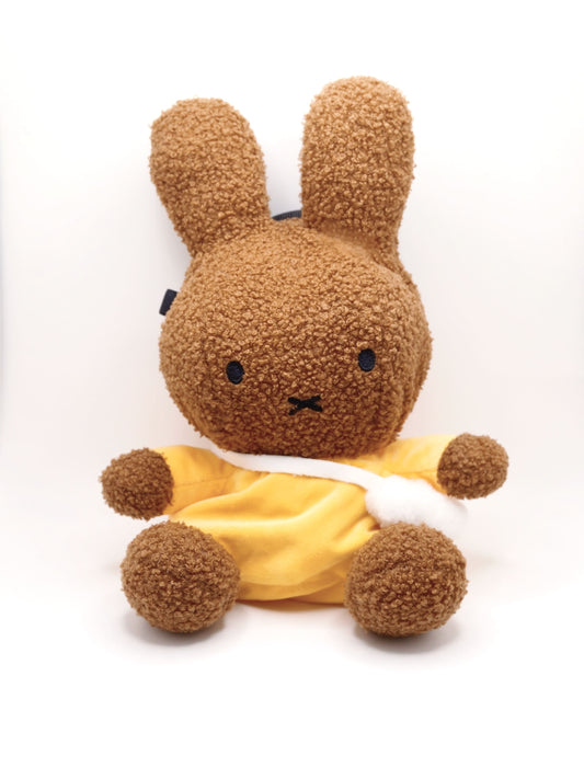 A cute anime plush chalk bag by FATWORM featuring a brown Mocha Bunny wearing a yellow dress. This functional and fluffy bouldering accessory is handmade for bouldering and climbing for rock climbing, offering a long-durable design that makes the perfect climbing gift for a climber.