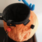 A cute anime plush chalk bag by FATWORM featuring an orange magical fire fruit with swirling flame patterns and a green stem, inspired by the fiery hero Ace. This functional and fluffy bouldering accessory is handmade for bouldering and climbing for rock climbing, offering a long-durable design that makes the perfect climbing gift for a climber.