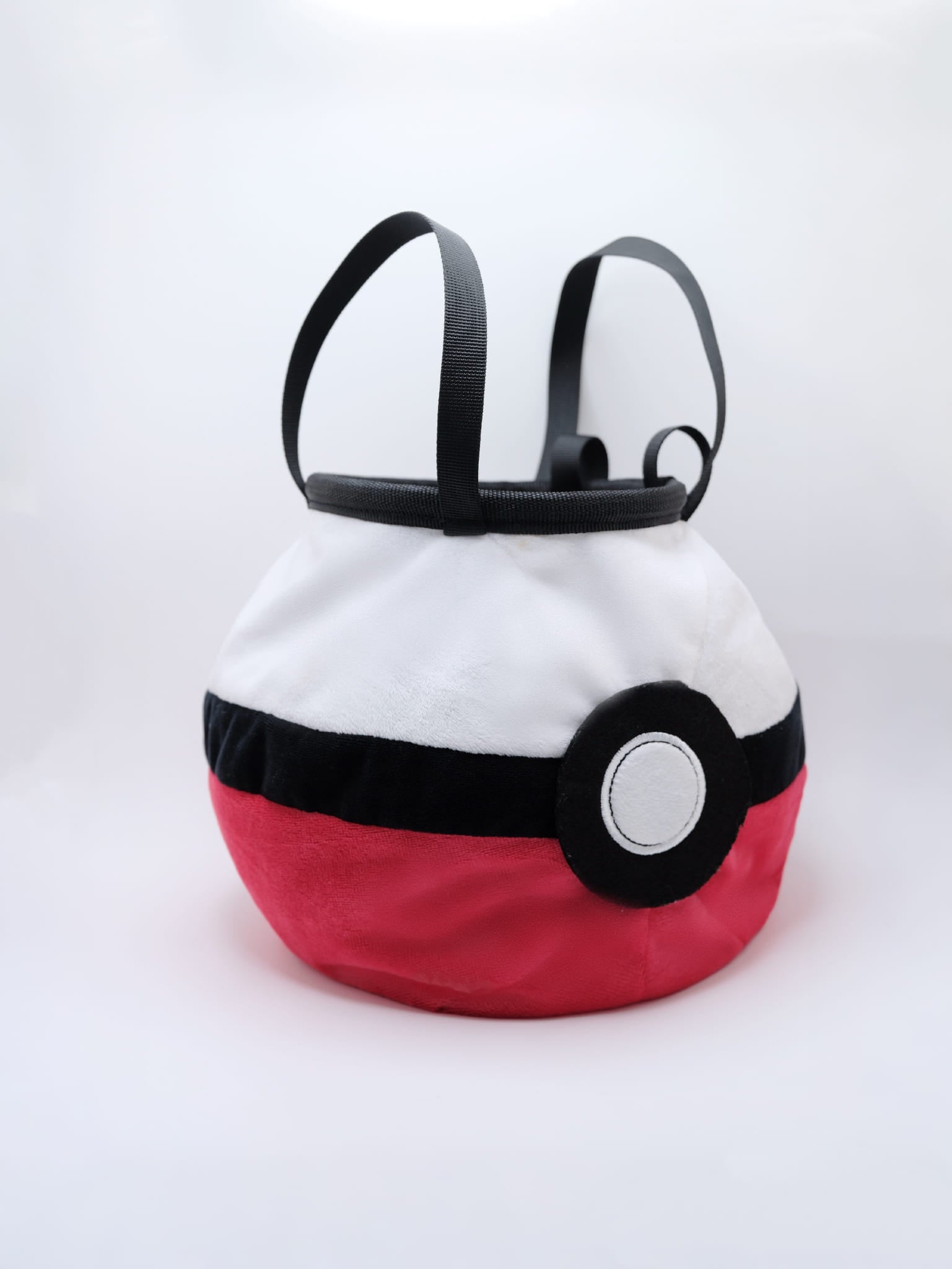 A soft and fluffy Poke Ball plush chalk bag by Fatworm. This cute yet functional climbing gear features the iconic red, white, and black design in a long-durable handmade construction. The perfect climbing gift for climbers who love gaming accessories.