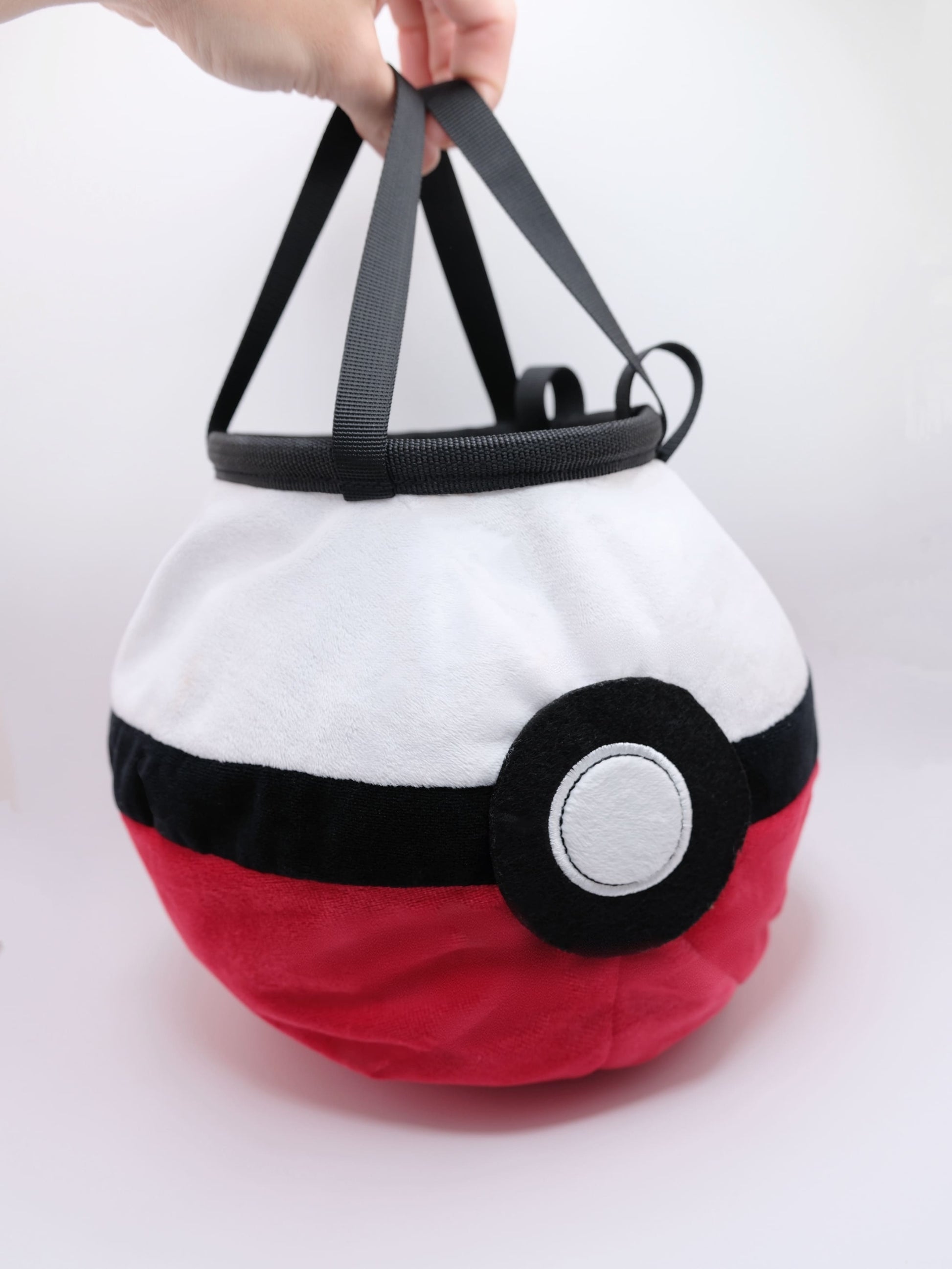 A soft and fluffy Poke Ball plush chalk bag by Fatworm. This cute yet functional climbing gear features the iconic red, white, and black design in a long-durable handmade construction. The perfect climbing gift for climbers who love gaming accessories.