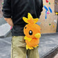 Handmade orange plush Torchic fire chick climbing chalk bag for bouldering. Features yellow feather tufts and a cute bird silhouette. High-quality plush bouldering gift with a 12cm reinforced rim, secure drawstring, and deep black fleece lining for rock climbing.