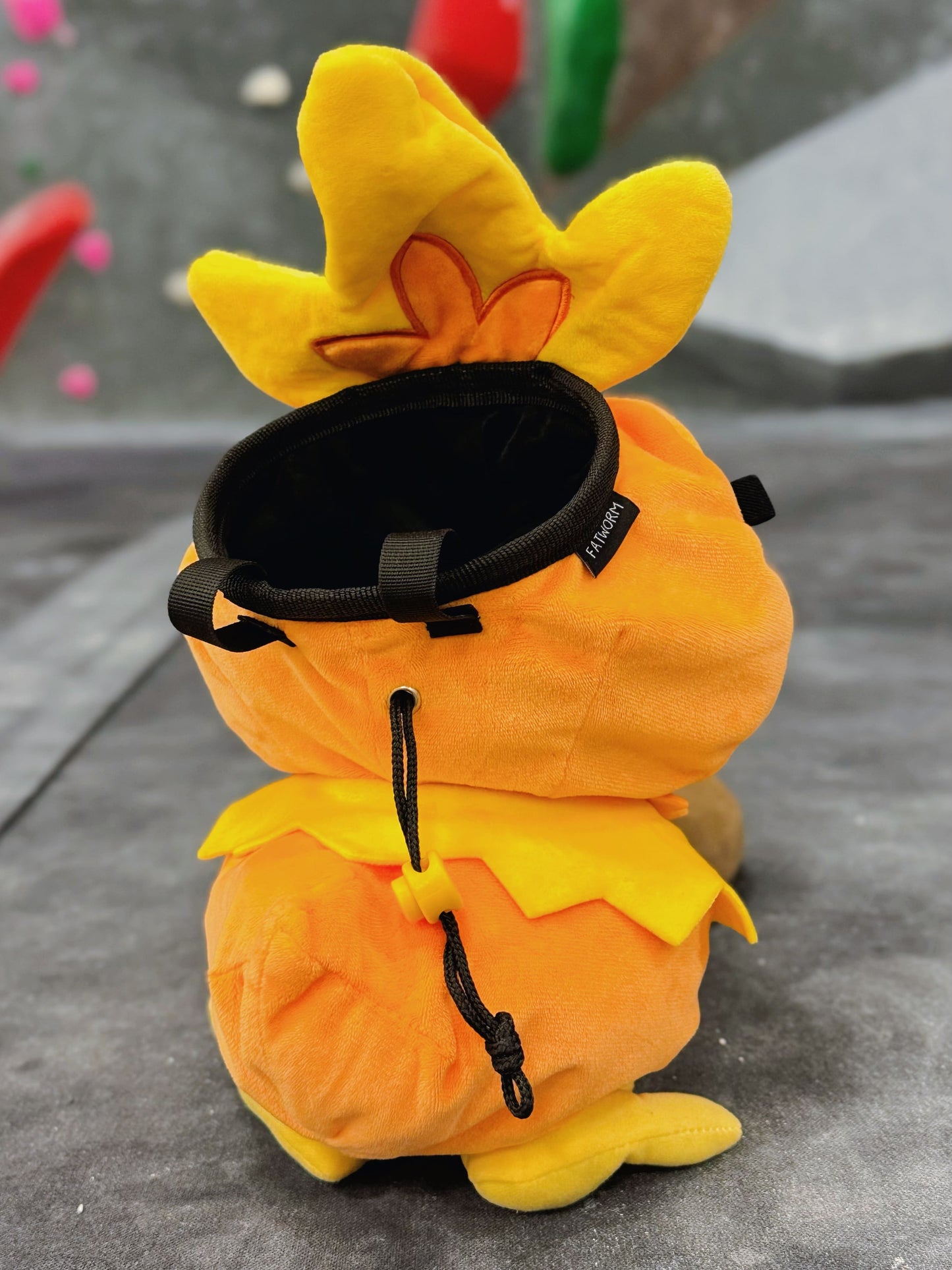 Handmade orange plush Torchic fire chick climbing chalk bag for bouldering. Features yellow feather tufts and a cute bird silhouette. High-quality plush bouldering gift with a 12cm reinforced rim, secure drawstring, and deep black fleece lining for rock climbing.