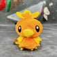 Handmade orange plush Torchic fire chick climbing chalk bag for bouldering. Features yellow feather tufts and a cute bird silhouette. High-quality plush bouldering gift with a 12cm reinforced rim, secure drawstring, and deep black fleece lining for rock climbing.